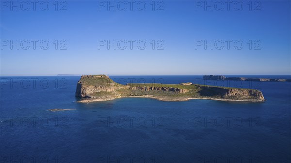 Drone shot, Small, secluded island with rocky coastline surrounded by the wide, blue sea under a clear sky, Venetian sea fortress, Gramvoussa, Gramvoussa peninsula, Pirate Bay, Balos, lagoon, north-west Crete, Crete, Greek islands, Greece, Europe