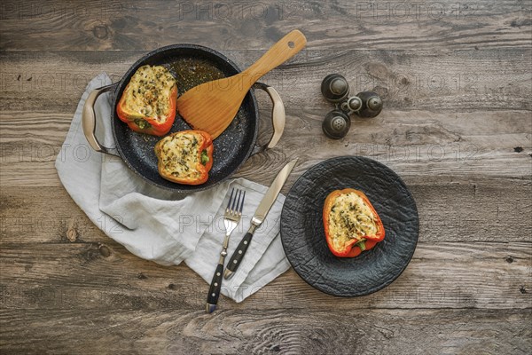 Overhead view of roasted bell peppers stuffed with goat cheese and mozzarella on wooden table