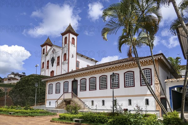 Wonderful decorated colonial building and a church in background at historical town Serro on a sunny day, Minas Gerais, Brazil, South America