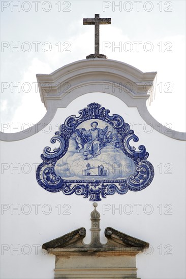 Historic azulejos painting at the church of Sao Lourenco de Matos near Almancil, Algarve, Portugal, Baroque ecclesiastical mural in blue and white with holy motif and cross at the top, Europe