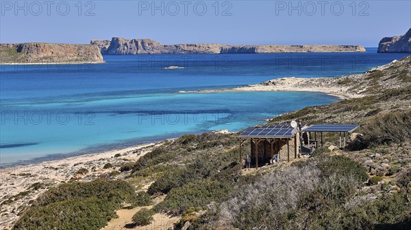 Caretaker building, coastal landscape with blue water, solar panels and green hills, quiet beach, Gramvoussa, Gramvoussa peninsula, Pirate Bay, Balos, lagoon, north-west Crete, Crete, Greek islands, Greece, Europe