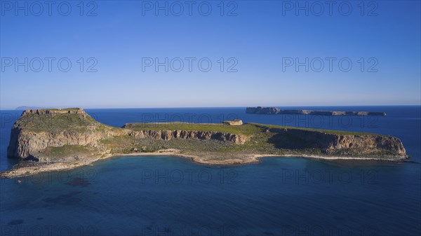 Drone shot, A flat island with steep cliffs and blue oceans all around under a clear sky, Venetian Sea Fortress, Gramvoussa, Gramvoussa Peninsula, Pirate Bay, Balos, Lagoon, Northwest Crete, Crete, Greek Islands, Greece, Europe