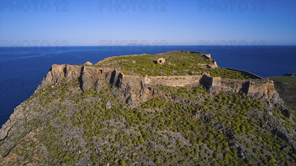 Drone shot, An old fortress perched on a green, rocky hill with sweeping sea views and surrounding cliffs, Venetian sea fortress, Gramvoussa, Gramvoussa Peninsula, Pirate Bay, Balos, Lagoon, Northwest Crete, Crete, Greek Islands, Greece, Europe