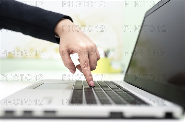 Businesswoman Typing Recent Updates On Lap Top Keyboard On Desk