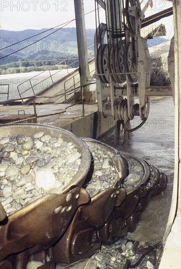 Bucket chain carries river bed gravel into the Ngahere Gold Dredge, West Coast, South Island, New Zealand, Oceania