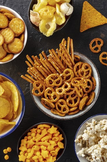 Salty snacks, party mix, shot from the top. An assortment of appetizers. Crackers, popcorn etc, Food photography