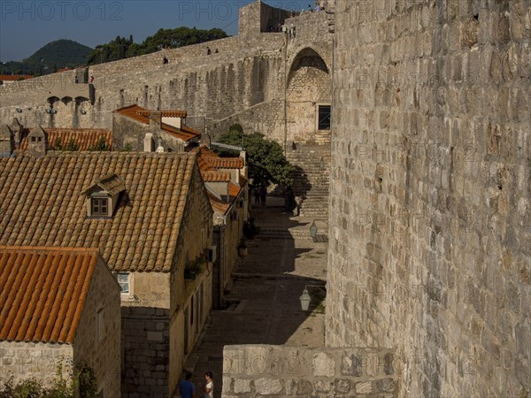 A narrow alley along a city wall with old houses and red roofs, dubrovnik, Mediterranean Sea, Croatia, Europe