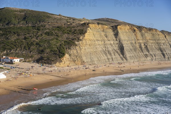 Magoito beach with surfers surfing on the sea waves in Sintra, Portugal, Europe