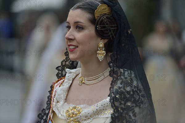 Fallas festival, woman in a traditional costume during the parade in the Plaza de la Virgen de los Desamparados, Valencia, Spain, Europe