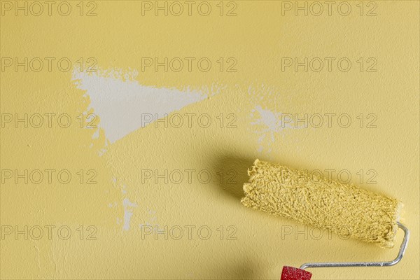 Unfinished painted wall with paint roller