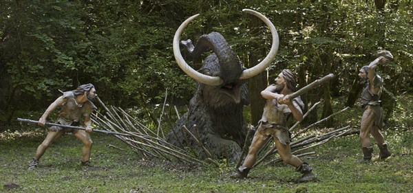 Diorama showing Neanderthal hunters killing trapped prehistoric mammoth at Prehisto Parc, theme park about prehistoric life at Tursac, Périgord, Dordogne, France, Europe