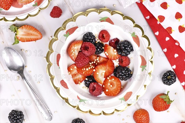 Top view of berry mix yogurt bowl with strawberry, raspberry and blackberry fruits and puffed quinoa