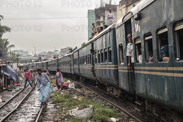 A train passes through an informal settlement built close to a railway line, Tejgaon Slum, Area, Dhaka, Bangladesh, Asia