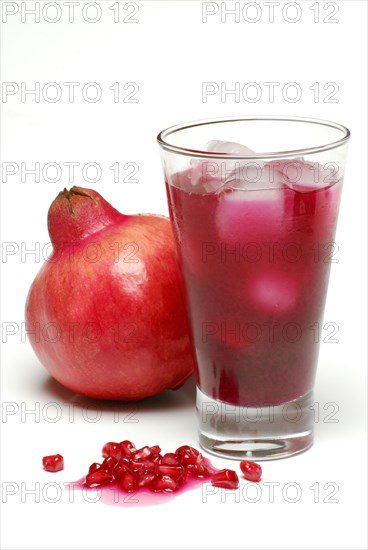 Pomegranate, pomegranate juice and pomegranate seeds, glass, ice cube cubes