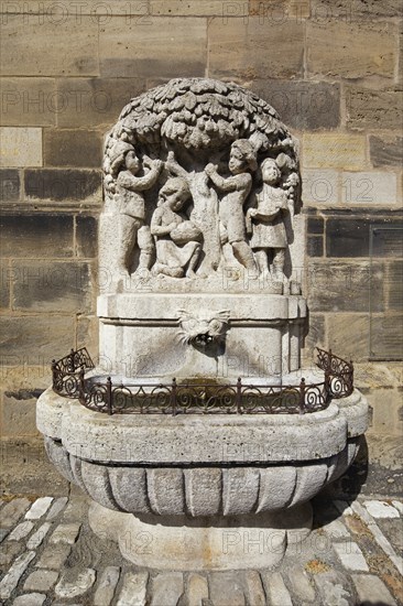 Güllbrünnlein, fountain, stone relief with children under plum tree, illustrated poem Pflaumenregen by the Ansbach poet Friedrich Wilhelm Güll 1812, 1879, at Johanniskirche, Ansbach, Middle Franconia, Franconia, Bavaria, Germany, Europe