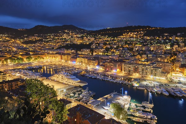 View of Old Port of Nice with luxury yacht boats from Castle Hill, France, Villefranche-sur-Mer, Nice, Cote d'Azur, French Riviera in the evening blue hour twilight illuminated, Europe