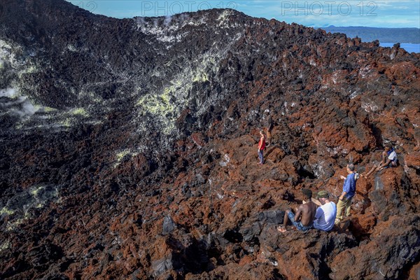 Hikers at the crater rim of the still active volcano Mount Tavurvur, Rabaul, East New Britain, Bismarck Archipelago, Papua New Guinea, Oceania