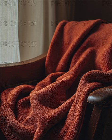 A red blanket draped over a wooden chair near a window with sheer curtains, creating a cozy and inviting atmosphere AI generated