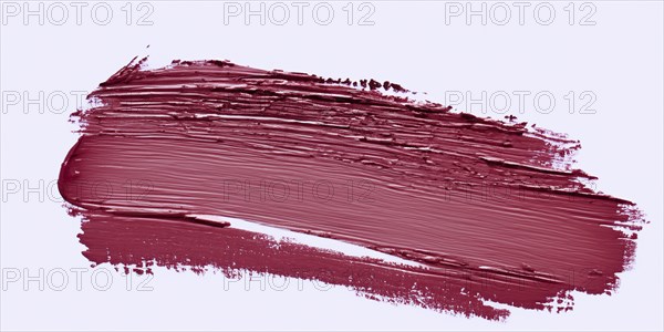 The white backdrop hosts vibrant lipstick strokes, creating a striking and colorful contrast