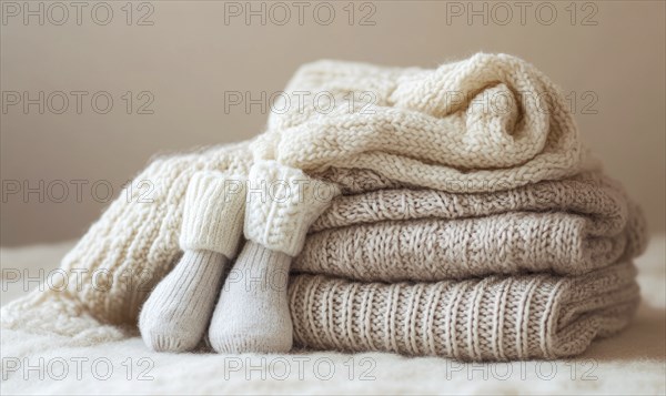 Soft knitted clothes in warm colors, laid out on a pastel background AI generated