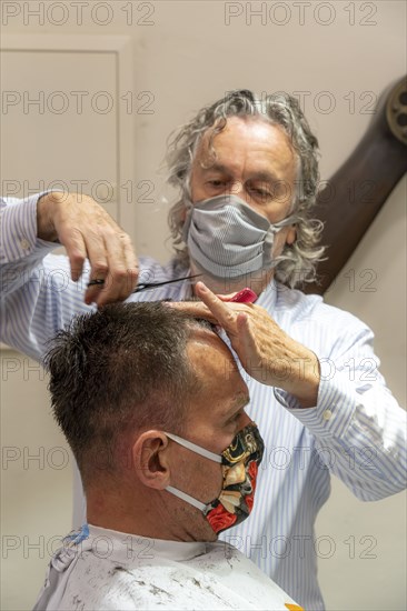 Hairdressing salon in Essen-Rüttenscheid, first customer after 6 weeks, shop closed due to Corona, hairdresser and customer with mouth-nose protection, breathing mask, distance regulation, Essen, North Rhine-Westphalia, Germany, Europe