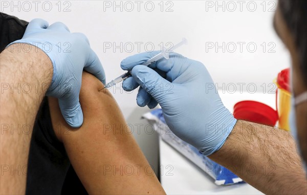 A woman receives a booster vaccination from Moderna against Covid 19 at the Schönefeld vaccination centre, 03.12.2021