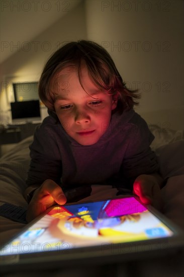 A boy plays computer games on a tablet PC