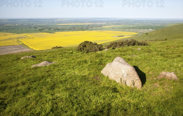 Sarsen stones on Milk Hill with a view over the Vale of Pewsey, Alton Barnes, Wiltshire, England, United Kingdom, Europe