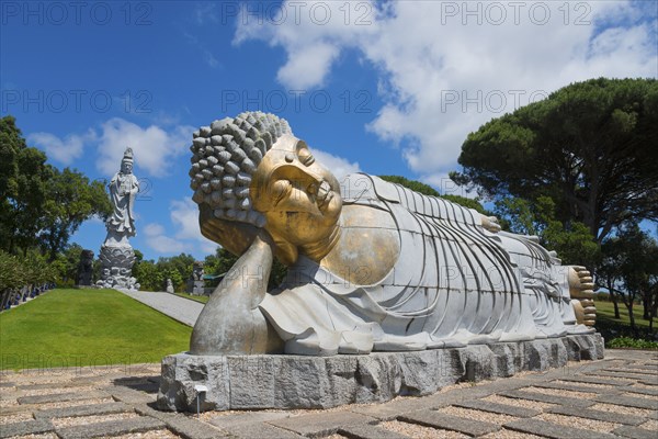 Monumental reclining Buddha statue in a green and peaceful park under a clear blue sky, Bacalhôa, Bacalhoa Buddha Eden, Quinta dos Loridos, largest oriental garden in Europe, Bombarral, Oeste, Centro, Portugal, Europe