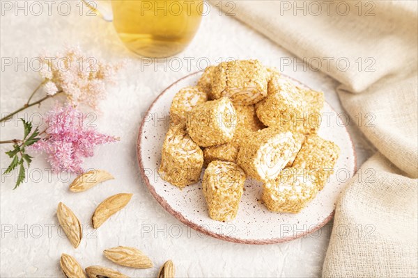 Traditional turkish delight (rahat lokum) with glass of green tea on a gray concrete background and linen textile. side view, selective focus, close up