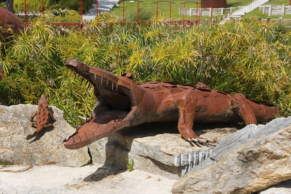 Metal sculpture of a crocodile with open mouth on a rock foundation surrounded by plants in the park, Bacalhôa, Bacalhoa Buddha Eden, Quinta dos Loridos, largest oriental garden in Europe, Bombarral, Oeste, Centro, Portugal, Europe