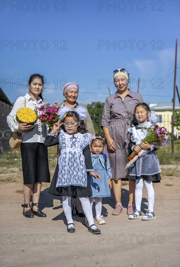 Family and schoolgirl with a bouquet of flowers on the first day of school, Issyk-Kul region, Kyrgyzstan, Asia