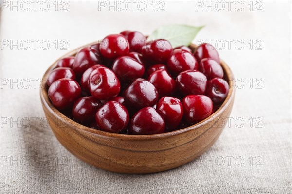 Fresh red sweet cherry in wooden bowl on wooden background. side view, close up