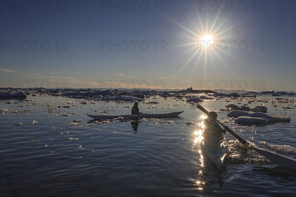 Inuit children paddling kayaks between icebergs, sunny, summer, Ilulissat, Ilulissat Icefjord, Disko Bay, West Greenland, Greenland, North America