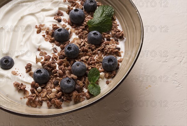 Yogurt with chocolate muesli, with berries, blueberries, breakfast, close-up, fork on top, no people