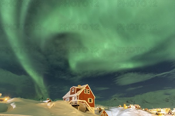 Northern Lights, Aurora borealis over red house, Inuit settlement, Winter, Tasiilaq, East Greenland, Greenland, North America