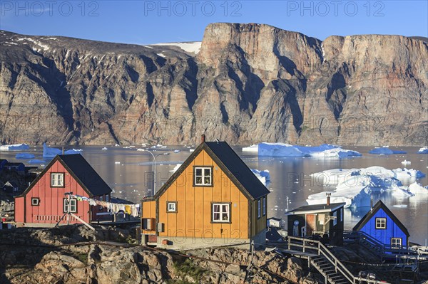 Typical Greenlandic houses in front of icebergs, Inuit settlement, summer, sunny, Uummannaq, West Greenland, Greenland, North America