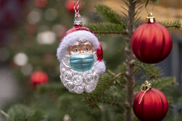 Symbolic image of Christmas in the Corona crisis, Father Christmas figure, Christmas tree decoration, with mouth and nose mask, everyday mask