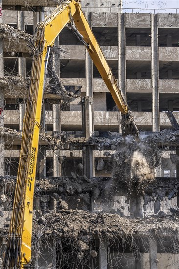 Construction site on Haroldstraße, demolition of a former office building, after complete gutting only the concrete parts remain, large excavator with cutting pliers cuts up concrete parts, steel wire, Düsseldorf, North Rhine-Westphalia, Germany, Europe