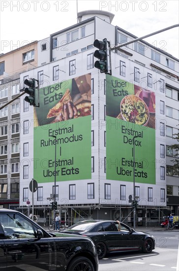 Large advertising banner, façade cladding, during construction work, advertising the food delivery service Uber Eats, Karlstraße, in Düsseldorf, North Rhine-Westphalia, Germany, Europe