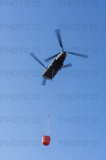 Forest fire in the German-Dutch border region near Niederkrüchten-Elmpt, in a nature reserve, use of fire-fighting helicopters, Boeing CH-47 Chinook helicopter, of the Dutch Air Force with extinguishing water tank, Bambi Bucket max