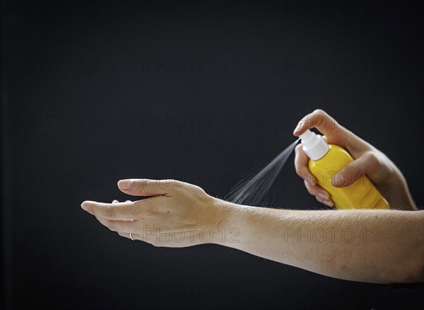 A person sprays a liquid on their arm in Berlin, 09/08/2024