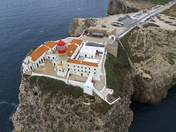 A red lighthouse on a cliff, surrounded by white buildings and a wide view of the ocean and the surrounding landscape, aerial view, lighthouse, Cabo de São Vicente, Cape St. Vincent, Cape St. Vincent, Sagres, Portugal, Europe