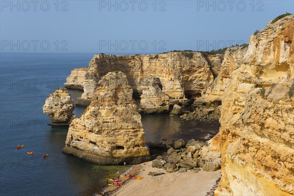 Majestic cliffs meet the calm sea on a sunny day with a golden sandy beach and blue sky, Praia da Marinha, Lagoa, Rocky Algarve, Algarve, Portugal, Europe