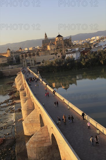 Roman bridge spanning river Rio Guadalquivir with Mezquita cathedral buildings, Cordoba, Spain, Europe