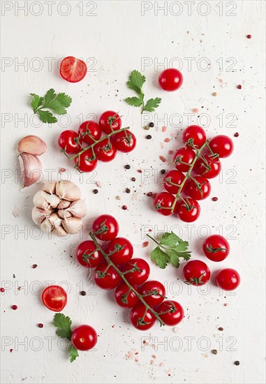 Branch with mini cherry tomatoes, with spices and herbs, garlic, food background, top view, on a white background