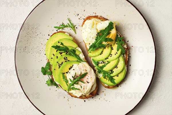 Sandwich with cream cheese, sliced avocado and boiled egg, arugula, on grainy bread, homemade, breakfast, no people