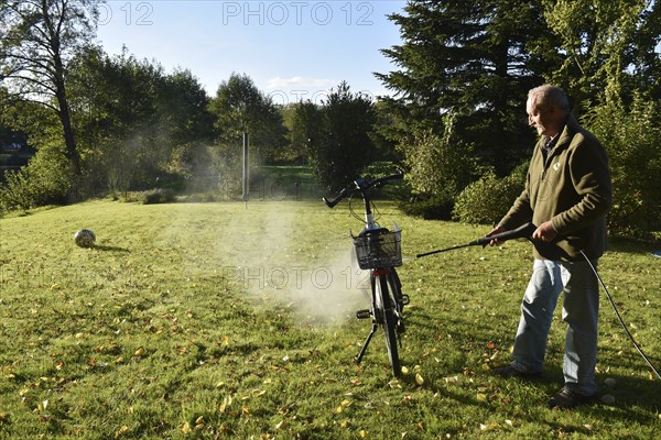 Man cleans bicycle with high-pressure cleaner