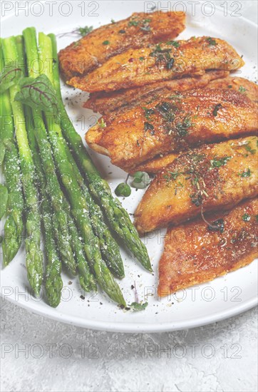 Fried fish fillet, tilapia with asparagus, homemade, no people