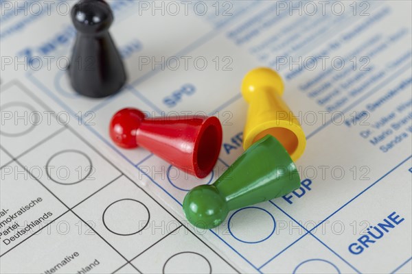 Symbolic image of poll results and election results in Germany: Overturned game pieces in the colours red (SPD), green (The Greens) and yellow (FDP) . The black playing piece (CDU) stands